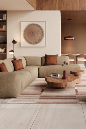 Beige hoekzetel in een warme woonkamer met houten salontafels, vloerkleed en eethoek op de achtergrond.