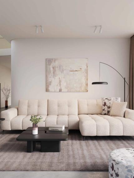 Canapé modulaire en tissu beige dans un salon moderne, avec tables basses noires, lampadaire arqué et grande fenêtre voilée.
