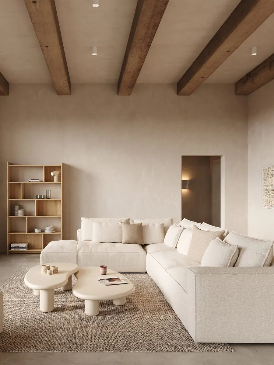 Salon Japandi lumineux avec un grand canapé d'angle, des tables basses organiques sur un tapis naturel et une étagère en bois ouverte à côté de la fenêtre.