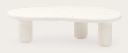 Table basse ovale de couleur claire, avec un plateau arrondi et trois pieds cylindriques, sur un fond neutre.