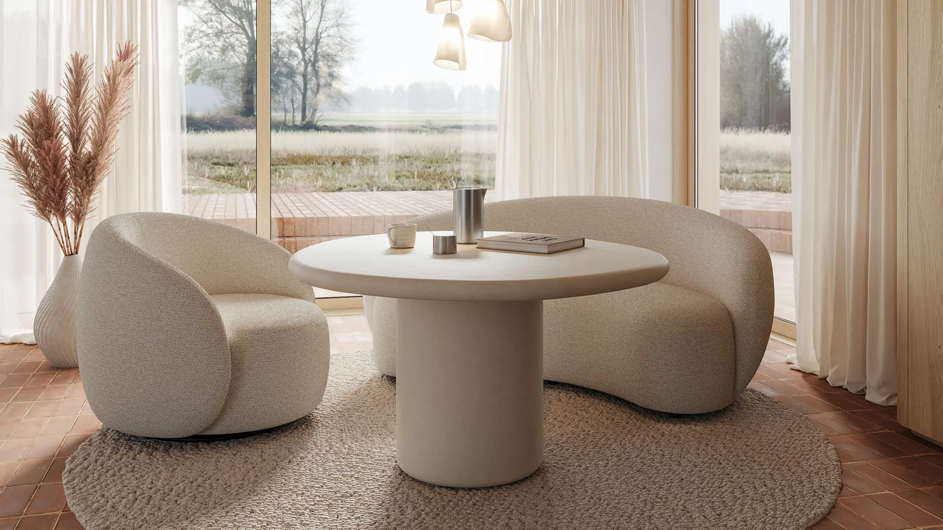 Ronde Artisano eettafel met centrale poot in een lichte ruimte, gecombineerd met twee afgeronde loungestoelen en grote ramen.