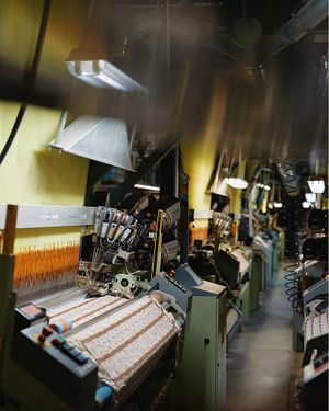 Machines de production textile dans un atelier, tissant des tissus aux différents motifs et textures.