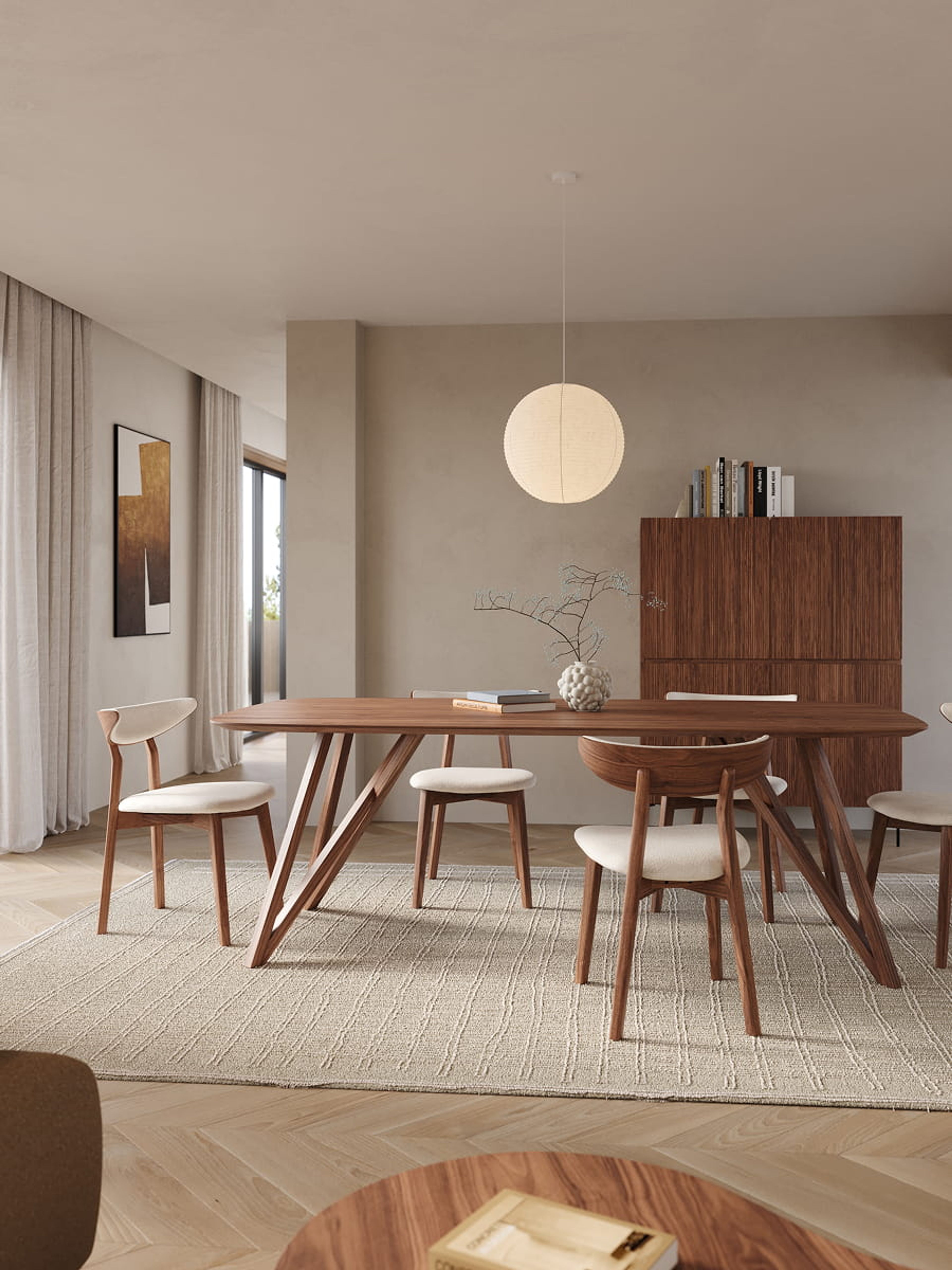 Beige tapijt Nanda onder een houten eettafel met designstoelen, in een lichte eetkamer met hanglamp, dressoir en zachte neutrale tinten.