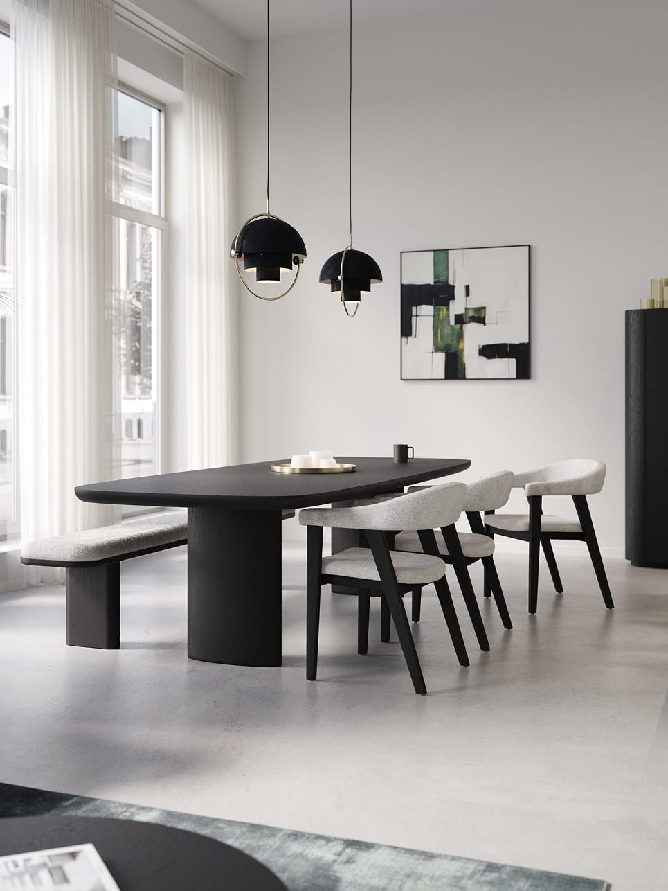Lange zwarte Amato eettafel met afgeronde hoeken, met lichte stoelen en bank in een rustige, lichte eetkamer.