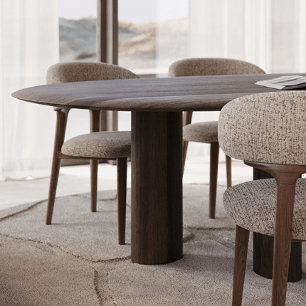 Detailbeeld van een lichte eettafel met een zacht afgerond, organisch gevormd tafelblad en subtiele steenstructuur, omringd door licht gestoffeerde stoelen met houten poten.
