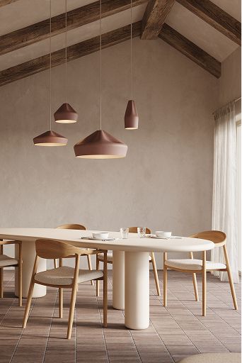 Salle à manger lumineuse avec table ovale et chaises en bois, suspensions aux tons chauds, grandes fenêtres sur l’extérieur et buffet minimaliste.