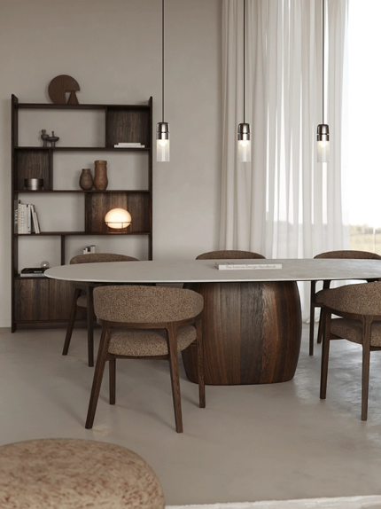 Warme woonkamer met een bruine hoekzetel, donkere salontafel en fauteuil in neutrale tinten.