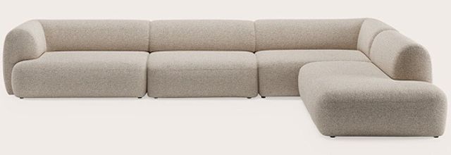 Modulaire hoekzetel met meerdere zitmodules en afgeronde armleuningen, bekleed met lichtbeige stof op neutrale achtergrond.