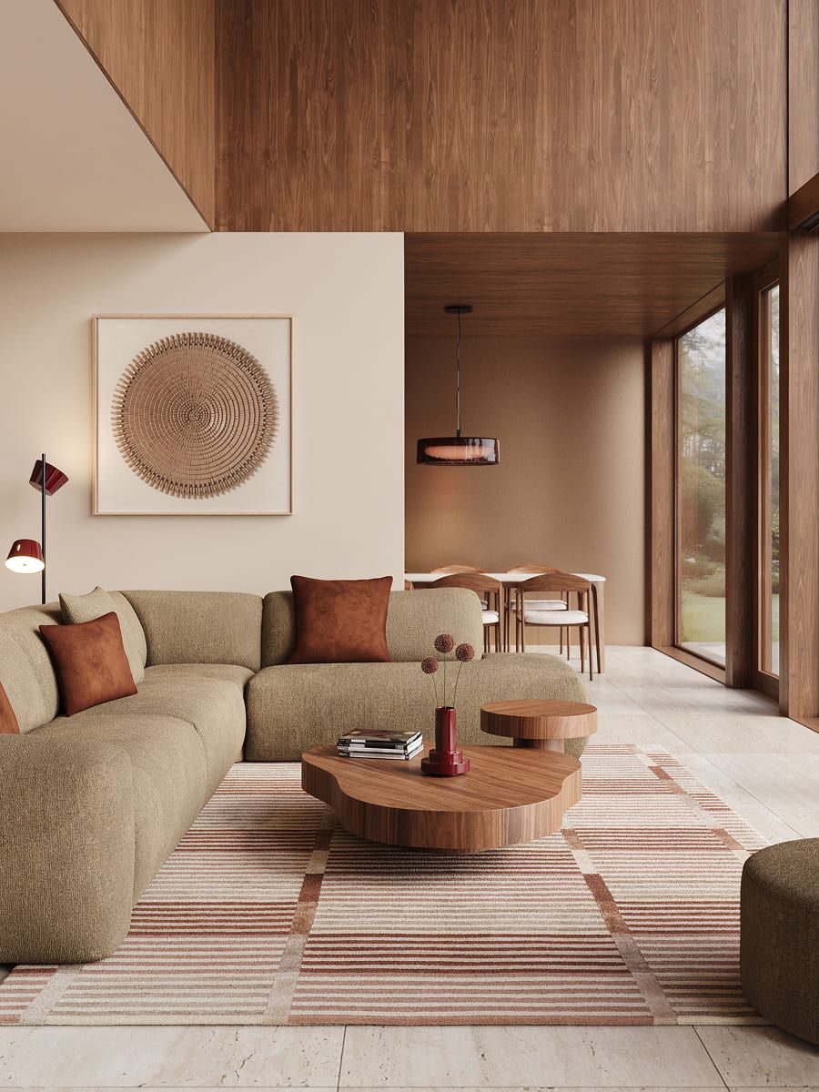Warme leefruimte met groene hoekzetel, organische houten salontafels en grote raampartijen in een interieur met houtaccenten.