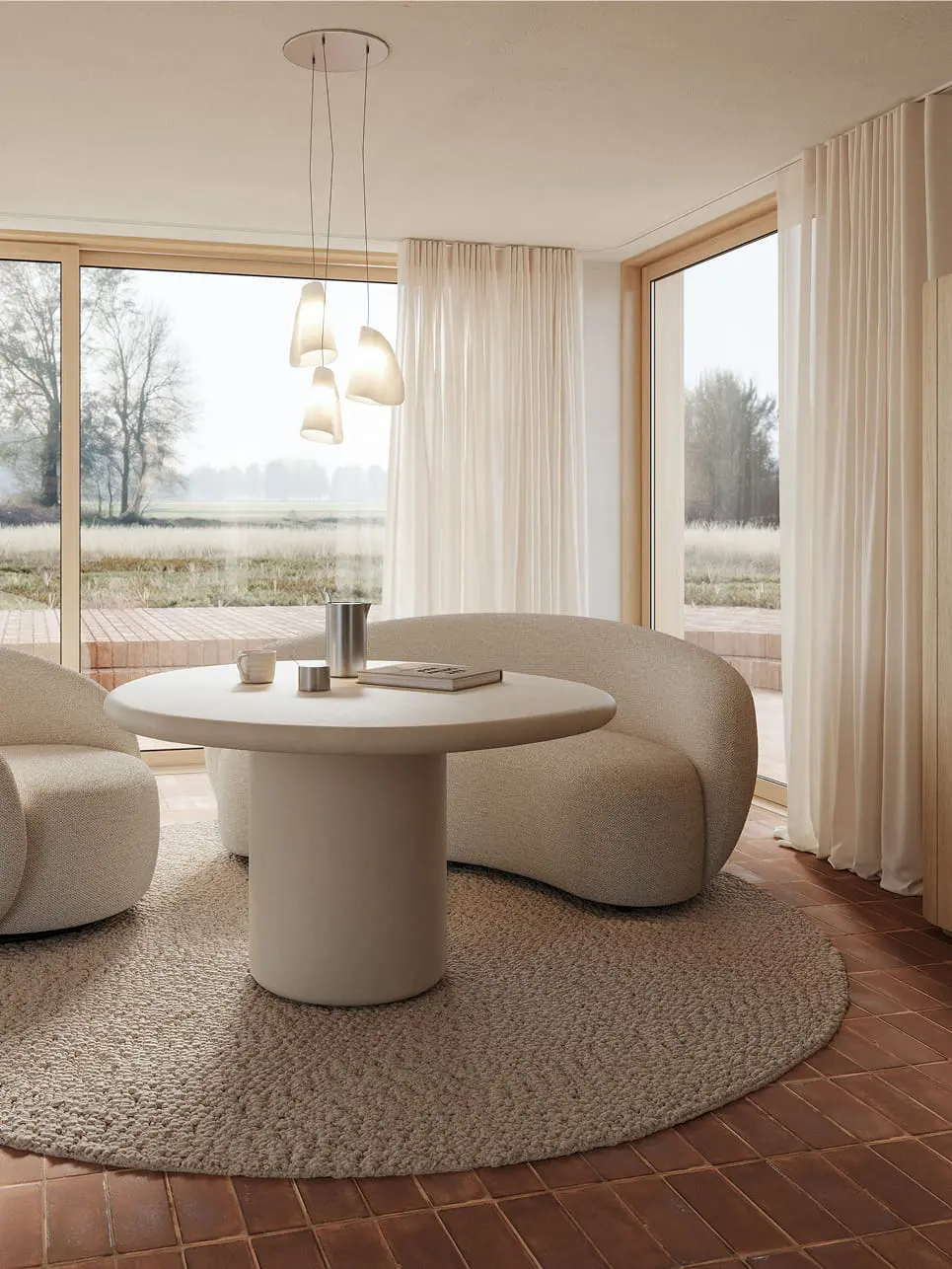 Ronde Artisano eettafel met centrale poot in een lichte ruimte, gecombineerd met twee afgeronde loungestoelen en grote ramen.