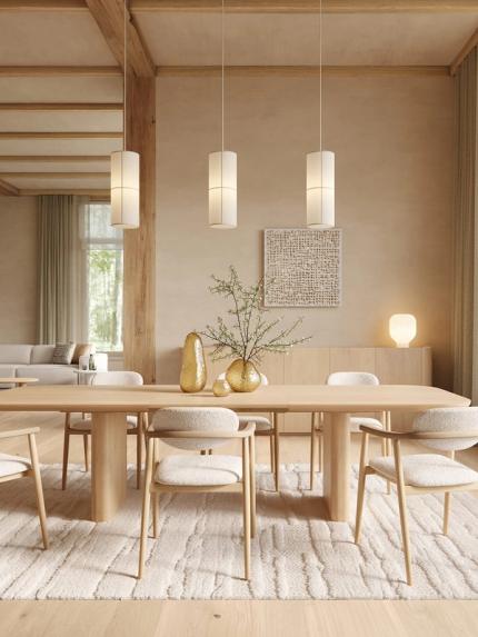 Raffinato kast in licht hout tegen een beige muur in een warm, minimalistisch interieur met eettafel en stoelen.