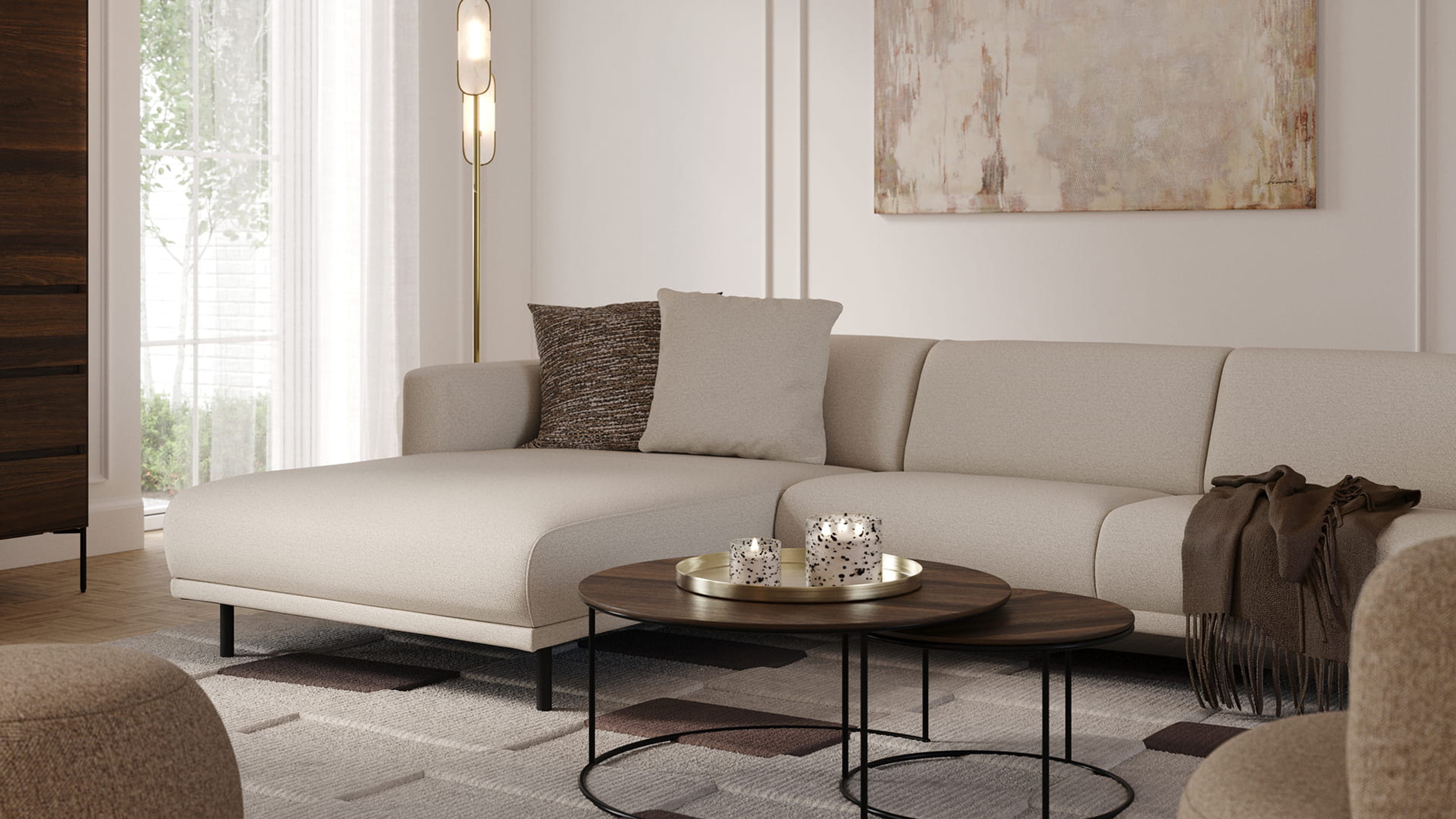 Canapé d’angle Evora beige clair avec méridienne dans un salon lumineux, avec tables basses rondes, lampadaire et tableau abstrait.