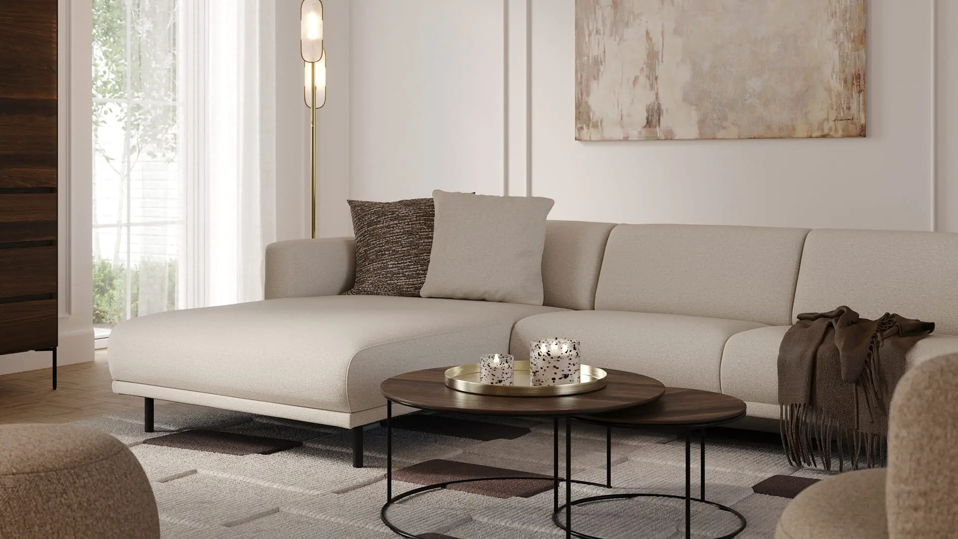 Canapé d’angle Evora beige clair avec méridienne dans un salon lumineux, avec tables basses rondes, lampadaire et tableau abstrait.