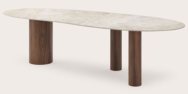 Table de salle à manger ovale avec plateau clair et trois pieds cylindriques en bois sur fond clair.