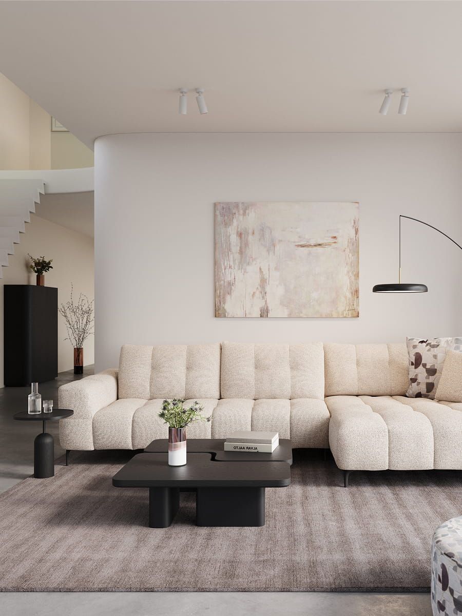 Canapé d’angle Campo beige avec assise profonde dans un salon moderne avec table basse noire, lampadaire et tons neutres.