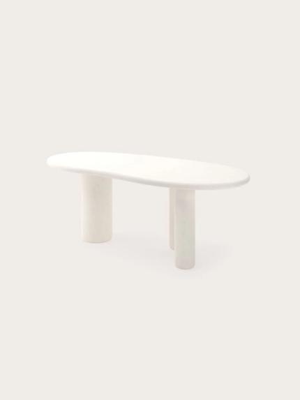 Witte organische eettafel met afgerond blad en drie cilindervormige poten.