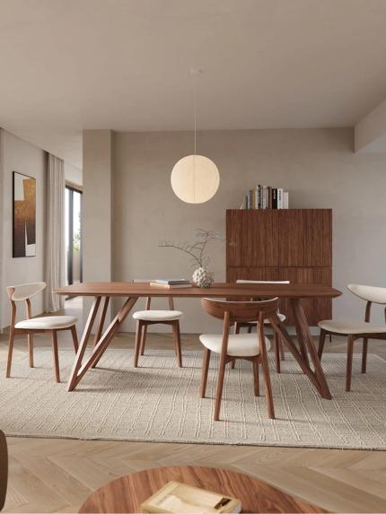 Armoire Grivolo en bois foncé derrière une table à manger en bois dans un intérieur moderne et chaleureux.