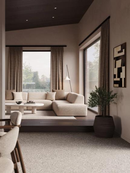 Canapé d’angle Porto beige dans un salon chaleureux avec grandes fenêtres, rideaux clairs, table basse ronde et sol en bois.