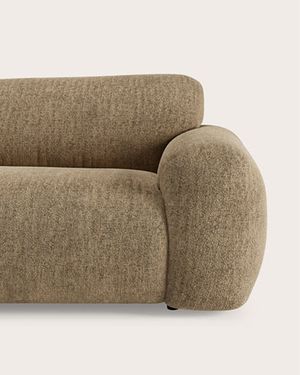 Modulaire hoekzetel in lichtbeige stof met chaise longue en zachte, afgeronde vormen.