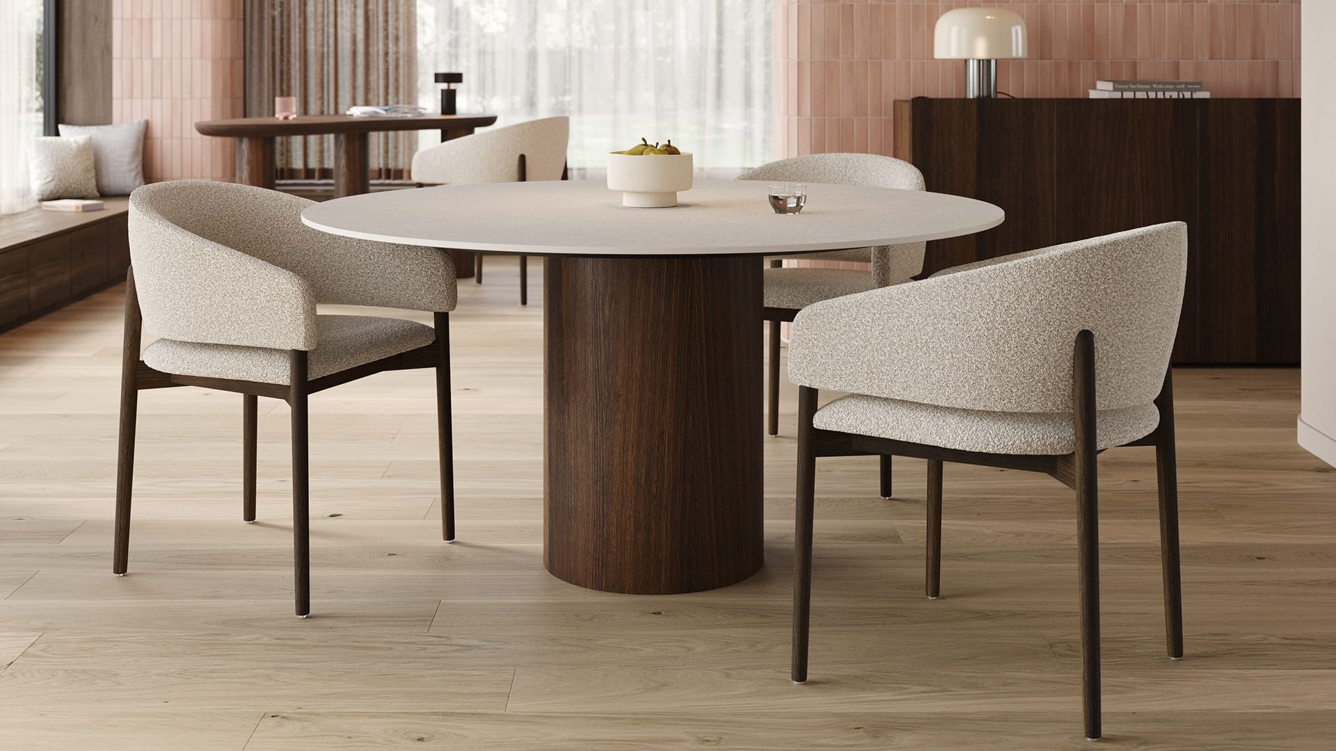 Ronde Amato eettafel met licht tafelblad en ronde houten poot, omringd door beige gestoffeerde stoelen in een warme eetkamer.