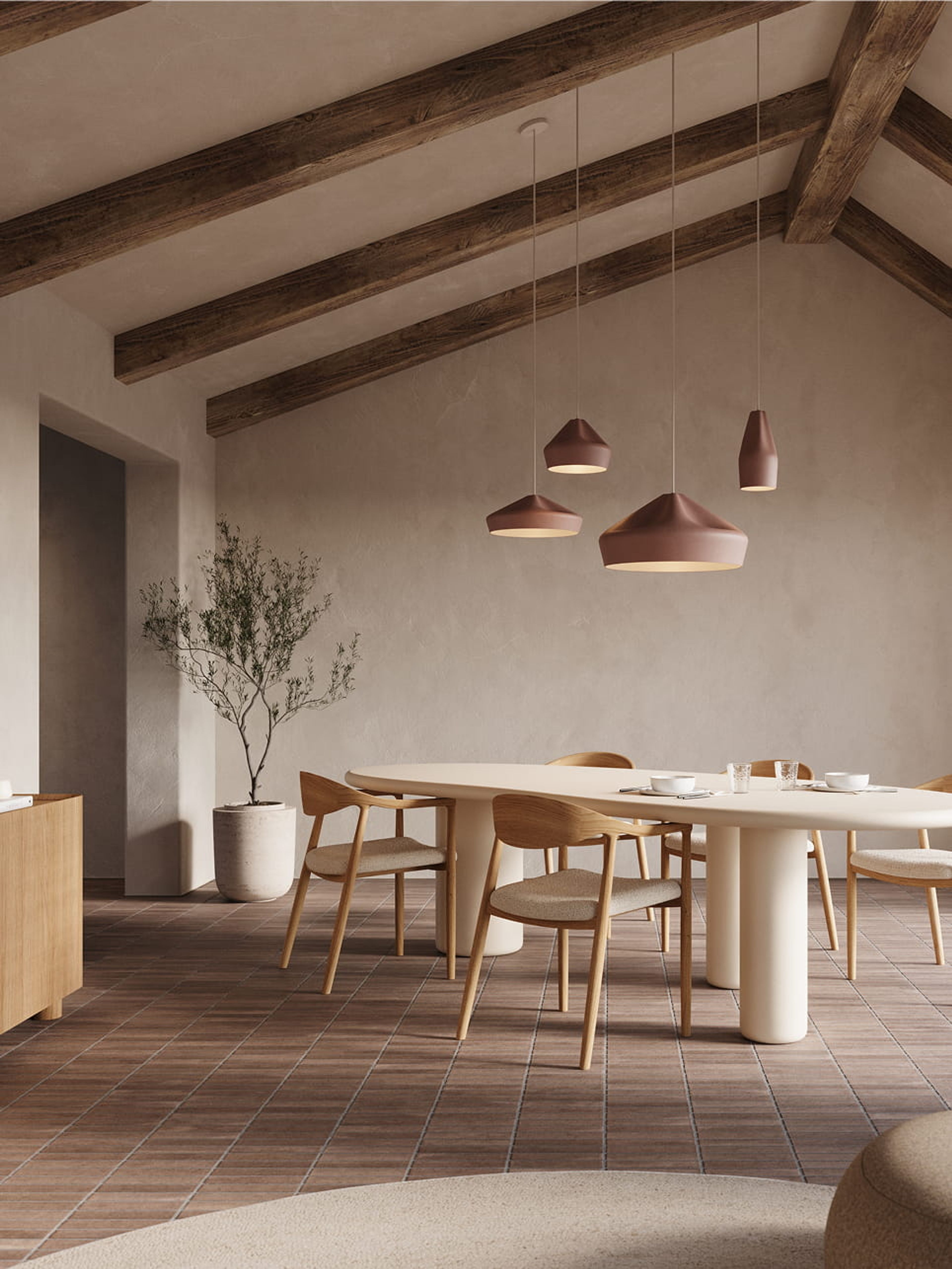 Lange Artisano eettafel met afgeronde vormen en centrale poten, in een warme ruimte met houten balken en lichte stoelen.