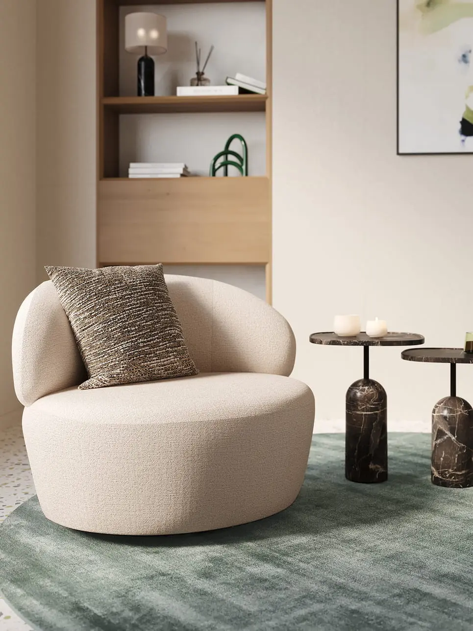 Norcia fauteuil met ronde, organische vorm in crèmekleurige stof, afgewerkt met een decoratief sierkussen in gemêleerde bruintinten.