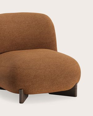 Fauteuil in warme bruine stof met afgeronde zitting en rugleuning en donkere poten.