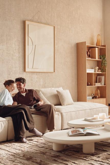 Een rustige en harmonieuze woonkamer die uitnodigt tot samen zijn, met zachte vormen, natuurlijke materialen en een verfijnd, gezellig interieur.
