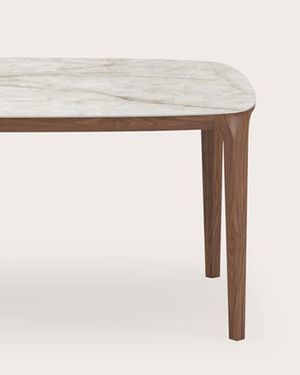Rechthoekige eettafel met licht natuurstenen blad en slanke poten in donker hout.