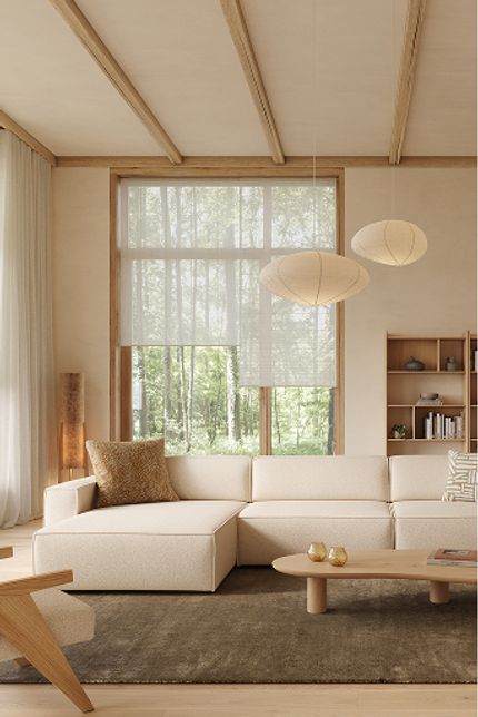 Japandi woonkamer met lichte hoekzetel, lage houten salontafel en ronde bijzettafel, in zachte naturel- en houttinten.