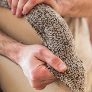 Gros plan sur des mains qui tendent le tissu d’habillage autour de l’assise de la chaise Cerso.