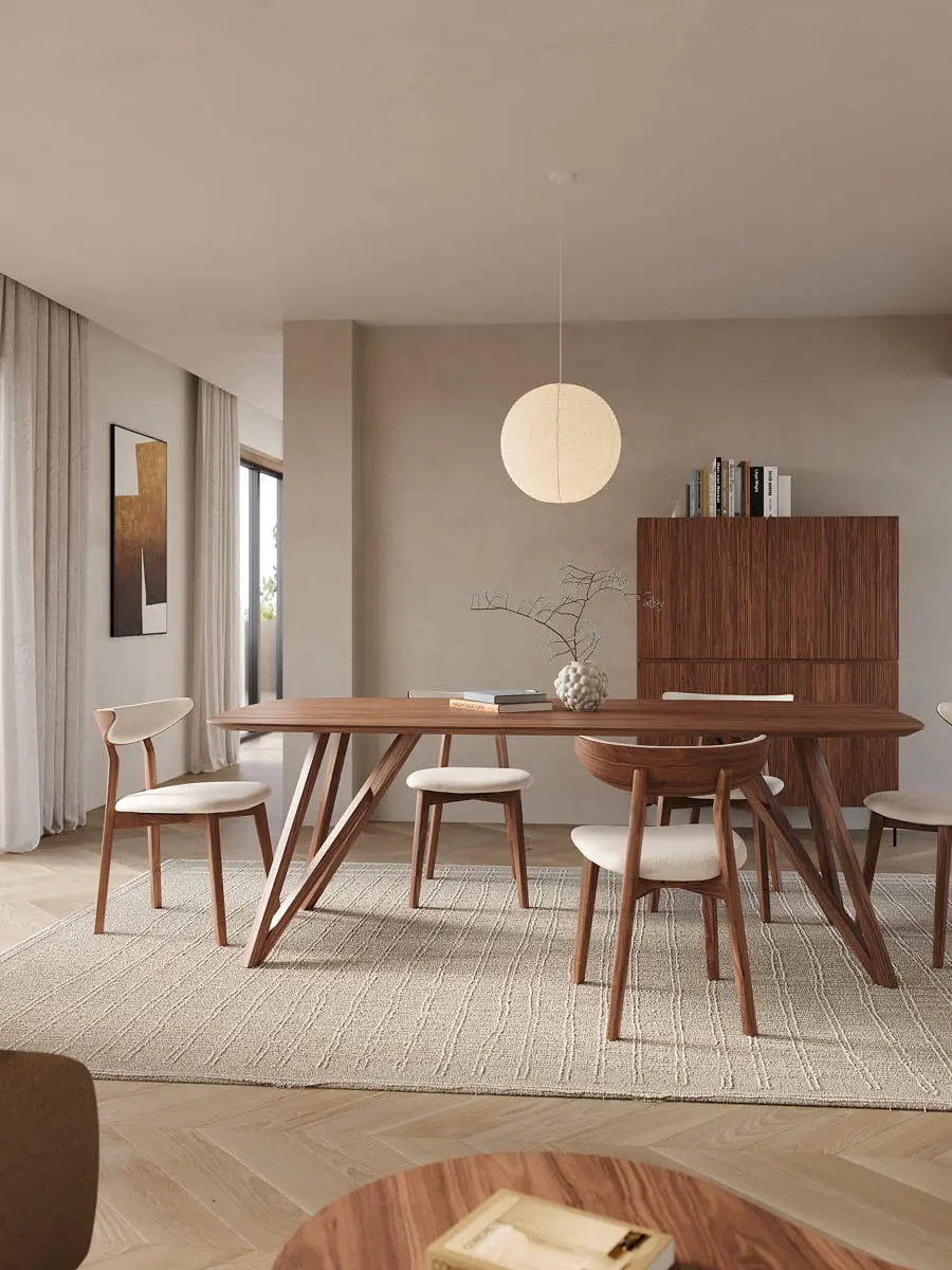 Lange houten eettafel met vijf lichtbeklede stoelen in een rustige eetkamer met ronde hanglamp en dressoir.