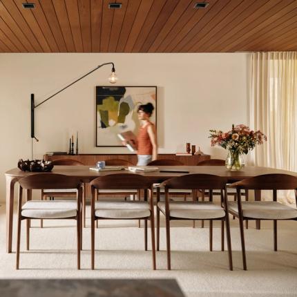 Chaises Cerso à structure en bois autour d’une table, dans une salle à manger lumineuse et chaleureuse.
