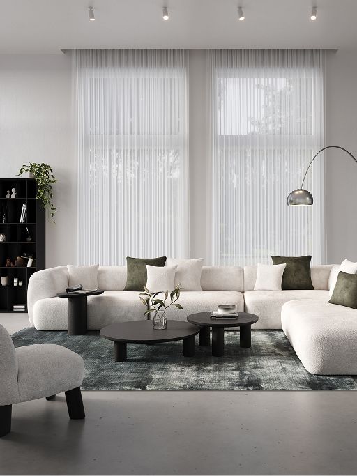 Beige woonkamer met modulaire Sarpi zetel, ronde houten salontafels, gestreept tapijt en grote ramen met zicht op de tuin.