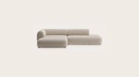 Beige modulaire Tortona-hoekzetel met ronde vormen, lage rug en chaise longue, vrijstaand op lichte achtergrond.