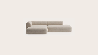 Beige modulaire Tortona-hoekzetel met ronde vormen, lage rug en chaise longue, vrijstaand op lichte achtergrond.