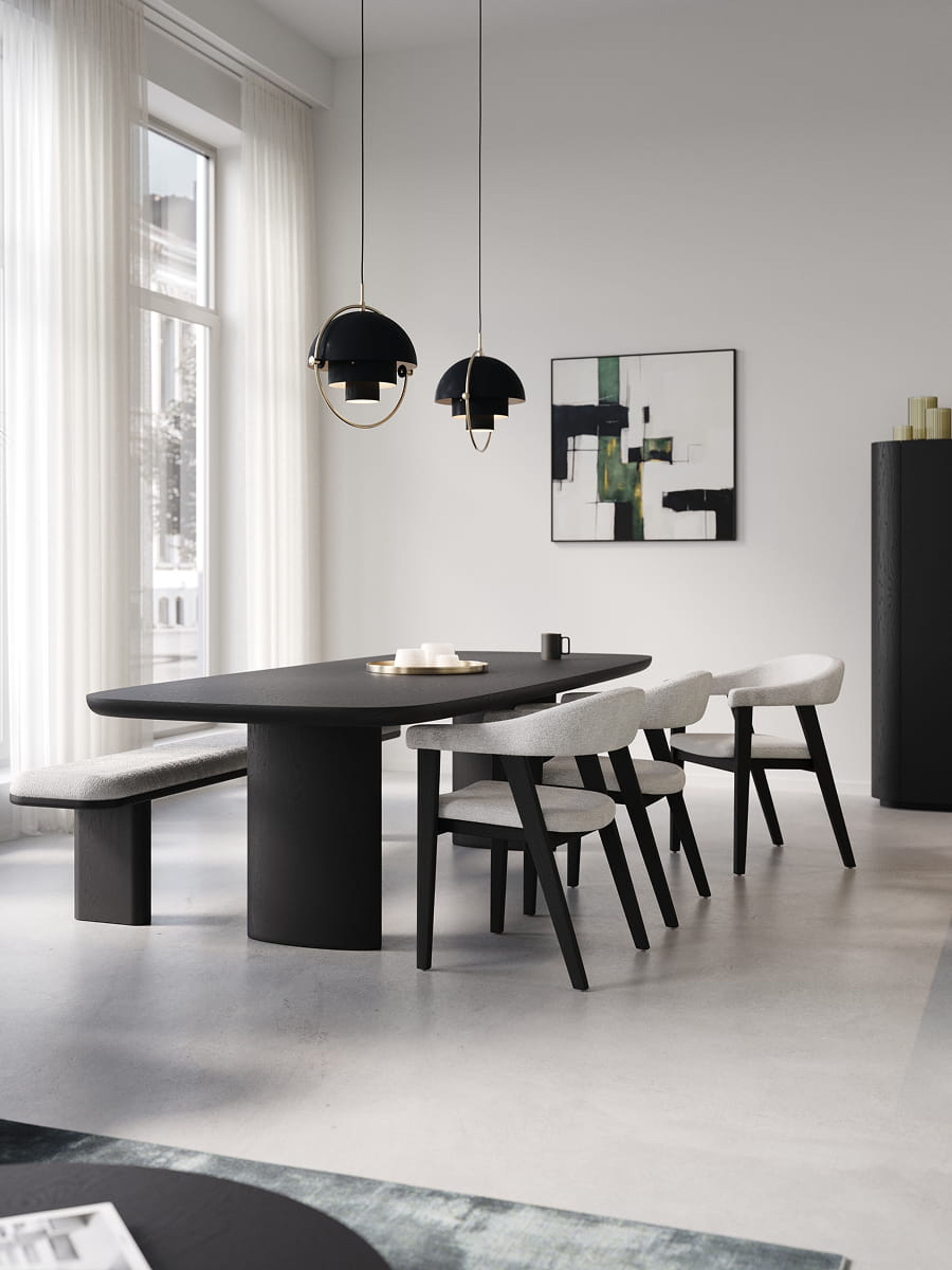 Eetkamer met zwarte tafel en Asiso stoelen met lichte bekleding, naast een bankje en grote ramen met zacht daglicht.