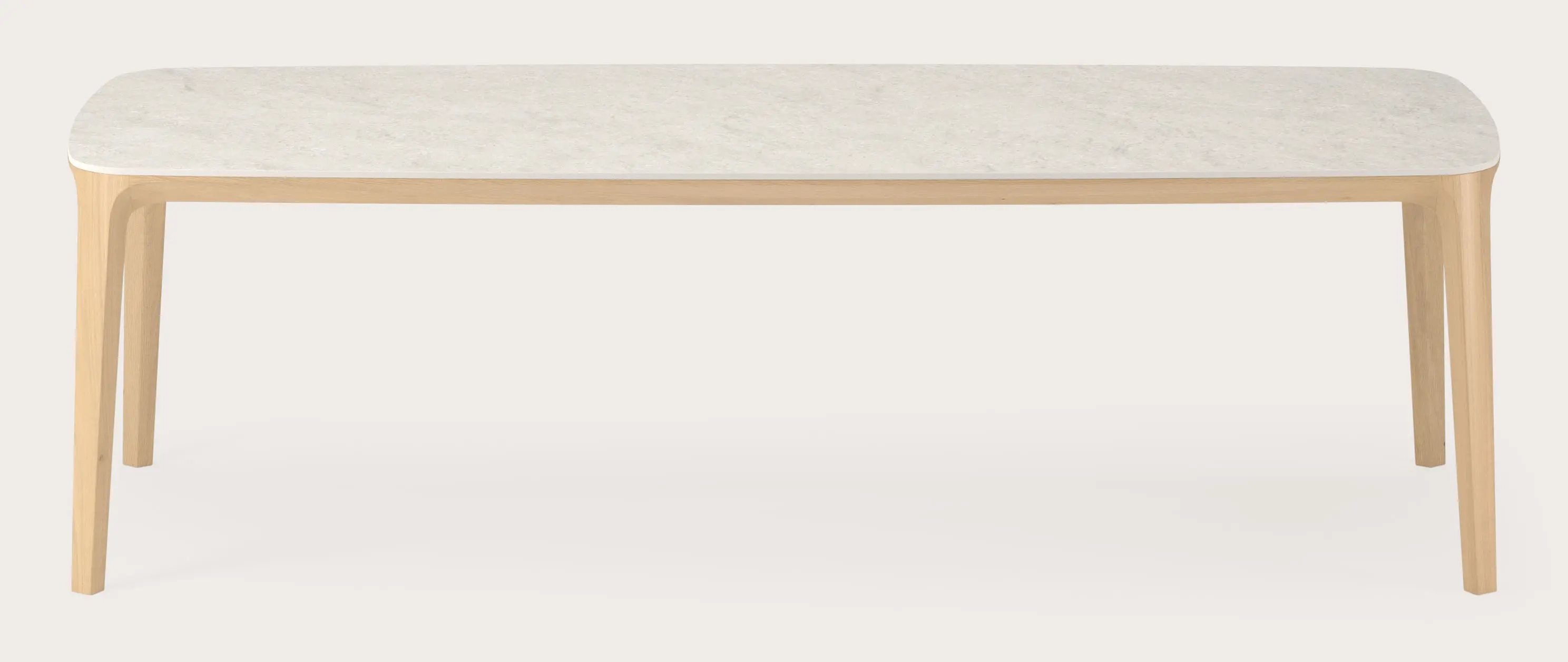 Rechthoekige eettafel met licht tafelblad en slanke houten poten op lichte achtergrond.