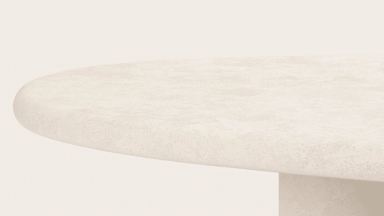 Close-up van een ronde tafel met een grof tafelblad met steenstructuur en een cilindervormig onderstel.