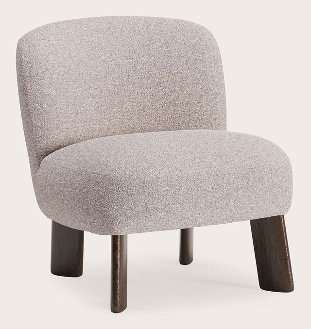 Compacte fauteuil in lichtgrijze stof met afgeronde rugleuning en zitting, op donkerhouten poten.