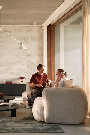 Couple dans un salon lumineux aux formes organiques et matières douces dans le style Delicate Encounters