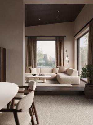 Lichte woonkamer met een beige modulaire hoekzetel, sierkussens en een witte ovale salontafel voor grote ramen.
