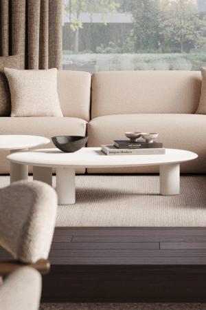 Witte organische salon- en bijzettafels voor een beige zetel in een lichte woonkamer met zicht op de tuin.