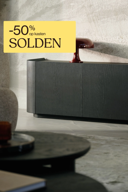 Lage, donkerhouten kast in moderne woonkamer met boeken en rode tafellamp op het blad.
