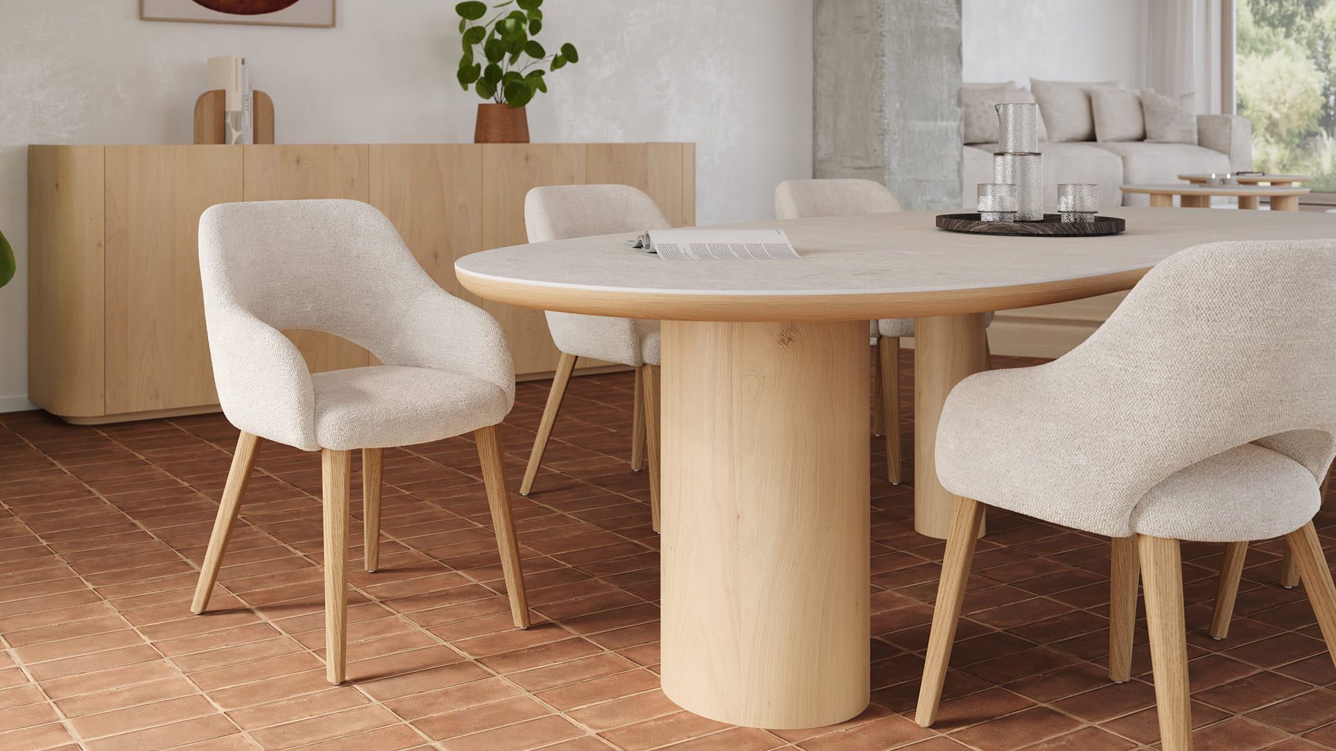 Ronde eettafel in licht hout met cilindervormige poten, omringd door beige gestoffeerde stoelen op houten poten in een warme eetruimte.
