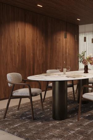 Eettafel met licht blad en donkere cilindervormige poten, gecombineerd met houten stoelen in een warme eetkamer.