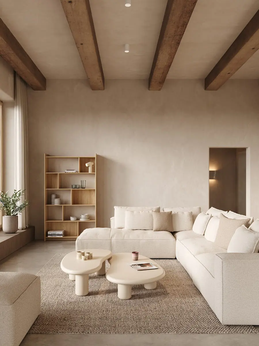 Salon beige avec canapé modulaire Duomo, tables basses rondes, bibliothèque en bois et grande fenêtre laissant entrer la lumière naturelle.