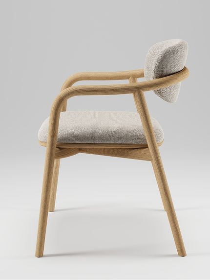 Vue de profil d’un fauteuil en bois aux lignes arrondies, avec une assise rembourrée claire et un dossier assorti.