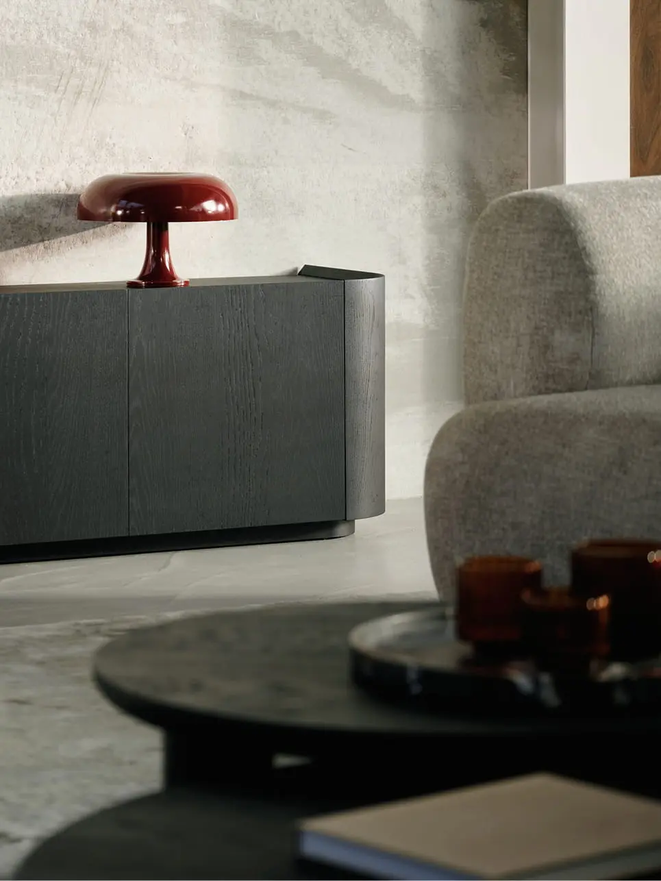 Buffet Rondato en bois foncé avec angles arrondis et façade épurée, placé dans un intérieur moderne avec une décoration subtile.