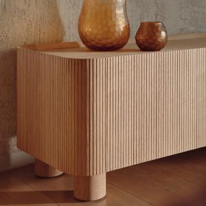 Een stijlvolle houten kast met verticaal geprofileerde lijnen, aangevuld met elegante glazen vazen. Het ontwerp benadrukt de textuur en het vakmanschap van het materiaal.